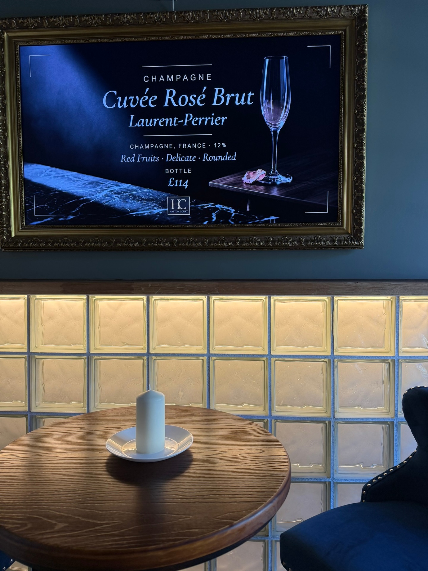 Framed Laurent-Perrier Cuvée Rosé Brut champagne feature above a candlelit bar table